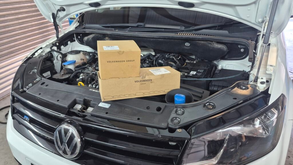 a boxed timing belt and water pump sitting on a car engine ready for installation